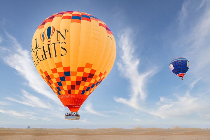 Soaring gently above the golden dunes experience the serene beauty of Dubai's desert at sunrise while savoring the thrill of a hot air balloon ride after a delightful breakfast.